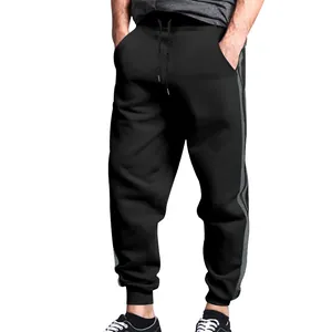Close-up of black men's joggers featuring iconic double side stripes and elastic cuffs.