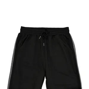 Close-up of men's black sports joggers featuring grey side stripes and elastic drawstring