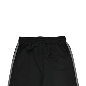 Detailed view of back pocket and elastic waistband on men's black side-stripe joggers