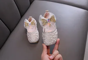 Detailed view of sparkly girls princess shoes with pearls, rhinestones and a large bow