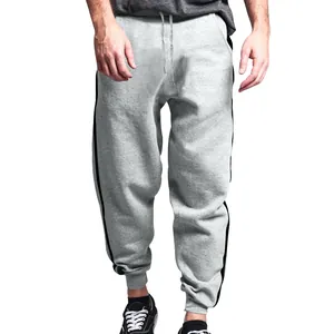 Front view of men's grey casual joggers with black side stripes worn by a model