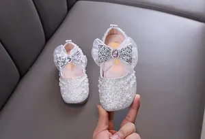 Detail of girl's princess flats with pearls and a rhinestone-studded mesh bow