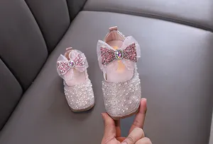 Detail view of pink girl's princess shoes with rhinestones and a large mesh bow