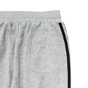 Detail view of grey men's casual joggers featuring elastic waist, back pocket and side stripe.