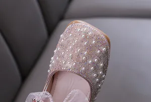 Close-up of sparkling rhinestones and pearls on a girls' princess dance shoe