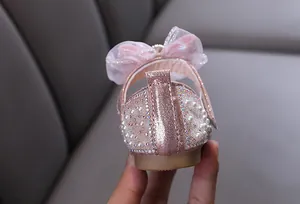 Close-up view of the pink princess shoe heel decorated with pearls and sparkly rhinestones