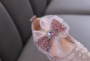 Detailed macro view of the sparkling rhinestone bow on girl's pink princess dress shoe