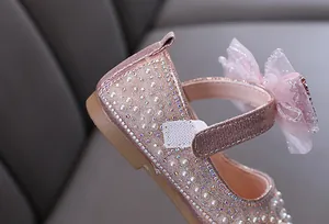 Detailed macro shot of pink girls princess shoes featuring sparkling rhinestones and pearls