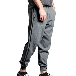 Close-up of men's grey joggers featuring black side stripes and ribbed ankle cuffs