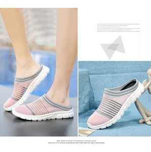 Detailed view of pink and grey breathable fly-knit slip-on mules with white sole.