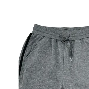 Detail of grey men's joggers showing elastic waist and two black side stripes.