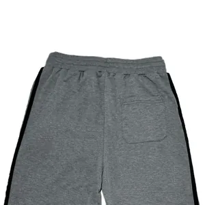 Close-up of back pocket detail on gray men's sports joggers with side stripes