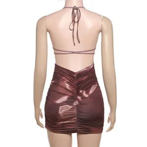 Detail of backless ruched mini dress with halter neck tie and marble print.