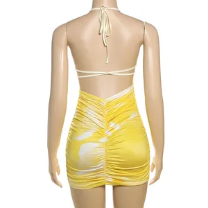 Back view of yellow tie-dye halter backless ruched bodycon mini dress on mannequin.