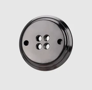 Gros plan d'un bouton en laiton noir haut de gamme avec un design unique à six trous