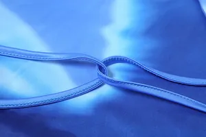 Macro detail showing blue gradient fabric and stitching of a halter bodycon dress.