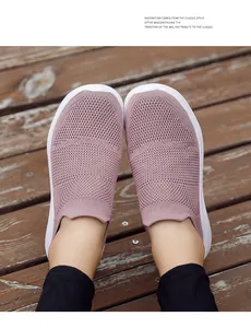 Close-up of mauve breathable flying knit slip-on sneakers for women on wood deck