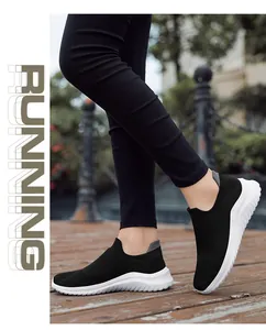 Black women's breathable fly-knit slip-on sock sneakers on wooden path