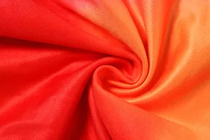 Macro view showing the soft texture and red orange gradient of the knitted fabric