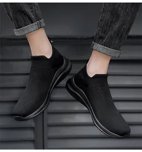 Dettaglio di sneaker a calzino in maglia nera traspirante da uomo con design slip-on