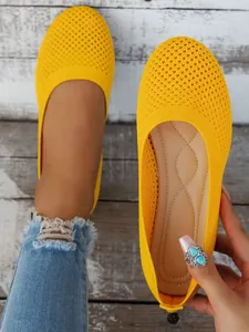 Close-up of yellow mesh flat shoes showing breathable texture and comfortable inner sole design