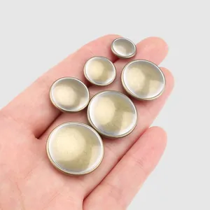Set of six assorted sizes high-quality brass metal buttons for clothing shown on palm