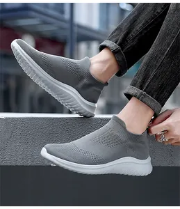 Vista laterale di sneakers a calzino grigie traspiranti da uomo con jeans neri sportivi