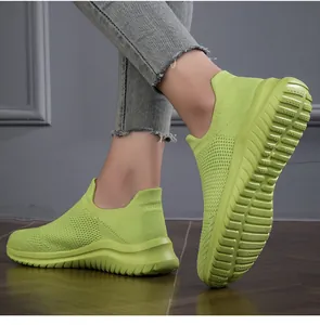 Detail of lime green knit sock shoes with breathable mesh and slip-on design.