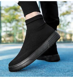 Close-up of breathable black knit sock sneakers on a blue outdoor court surface.
