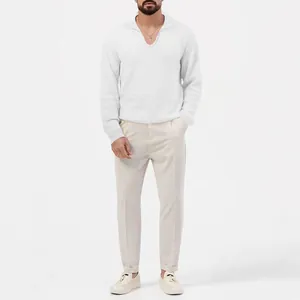 Ein männliches Model trägt ein weißes Langarm-Poloshirt mit feiner Waffelstruktur.