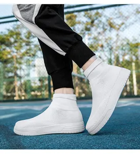 Detailed view of white breathable knitted high-top sock sneakers on a blue court
