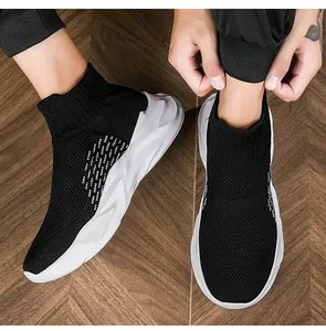 Detailansicht von schwarzen Socken-Sneakern mit dicker weißer Sohle auf Holzboden