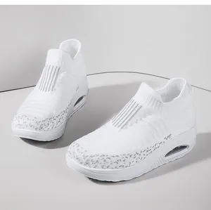 Detail view of white breathable fly-knit slip-on sneakers with thick air cushion sole