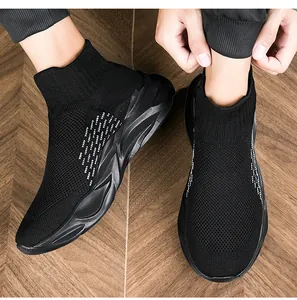Detaillierte Nahaufnahme von schwarzen Slip-On-Stricksneakern auf einem Holzboden