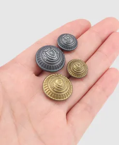 Vue détaillée de boutons en laiton vintage avec blason sur la main pour l'échelle