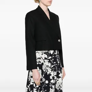 Premium metal button detail on a black cropped blazer worn by a model in profile