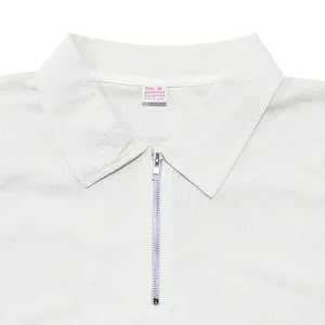 Dettaglio di una polo bianca da uomo con cerniera argentata ed etichetta sul collo.