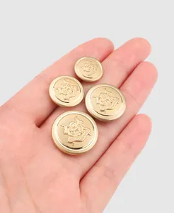 Close-up of four high-end embossed brass metal buttons with a decorative crest design