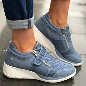 Close-up of stylish blue wedge sneakers with rhinestone details and velcro strap
