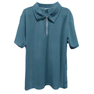 Primo piano di una polo da uomo a costine color ottanio con cerniera lampo frontale.