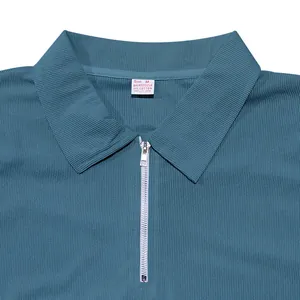 Primo piano della polo a coste verde-blu da uomo con zip e etichetta della taglia