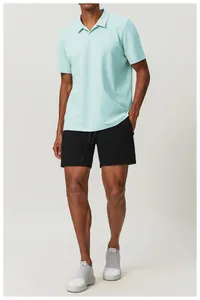 Detail view of men's breathable mint green polo shirt and black athletic shorts