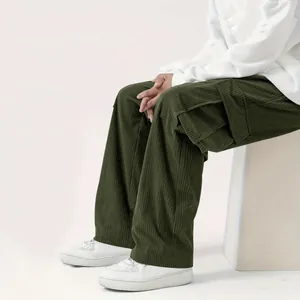 Dettaglio dei pantaloni cargo da uomo in velluto a coste verde scuro con tasche e trama