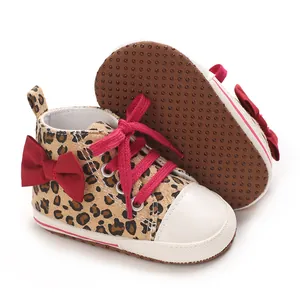 Detailansicht von Leopard-Baby-Sneakern mit roter Schleife und rutschfester Sohle.