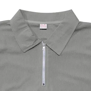 Dettaglio polo grigia da uomo con zip argentata e tessuto a costine di alta qualità.