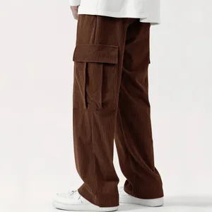 Dettaglio di pantaloni cargo in velluto a coste marroni con tasca laterale grande.