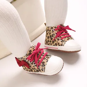 Detaillierte Ansicht der Babyschuhe mit Leopardenmuster, roter Schleife und weicher Sohle