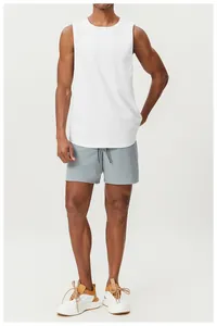 Man wearing a breathable white cotton sports tank top and grey athletic shorts