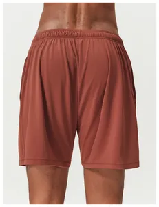 Back view detail of men's reddish-brown mesh athletic shorts for tennis and running