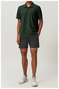 A full view of the dark green cotton polo shirt on a model showing the casual fit.